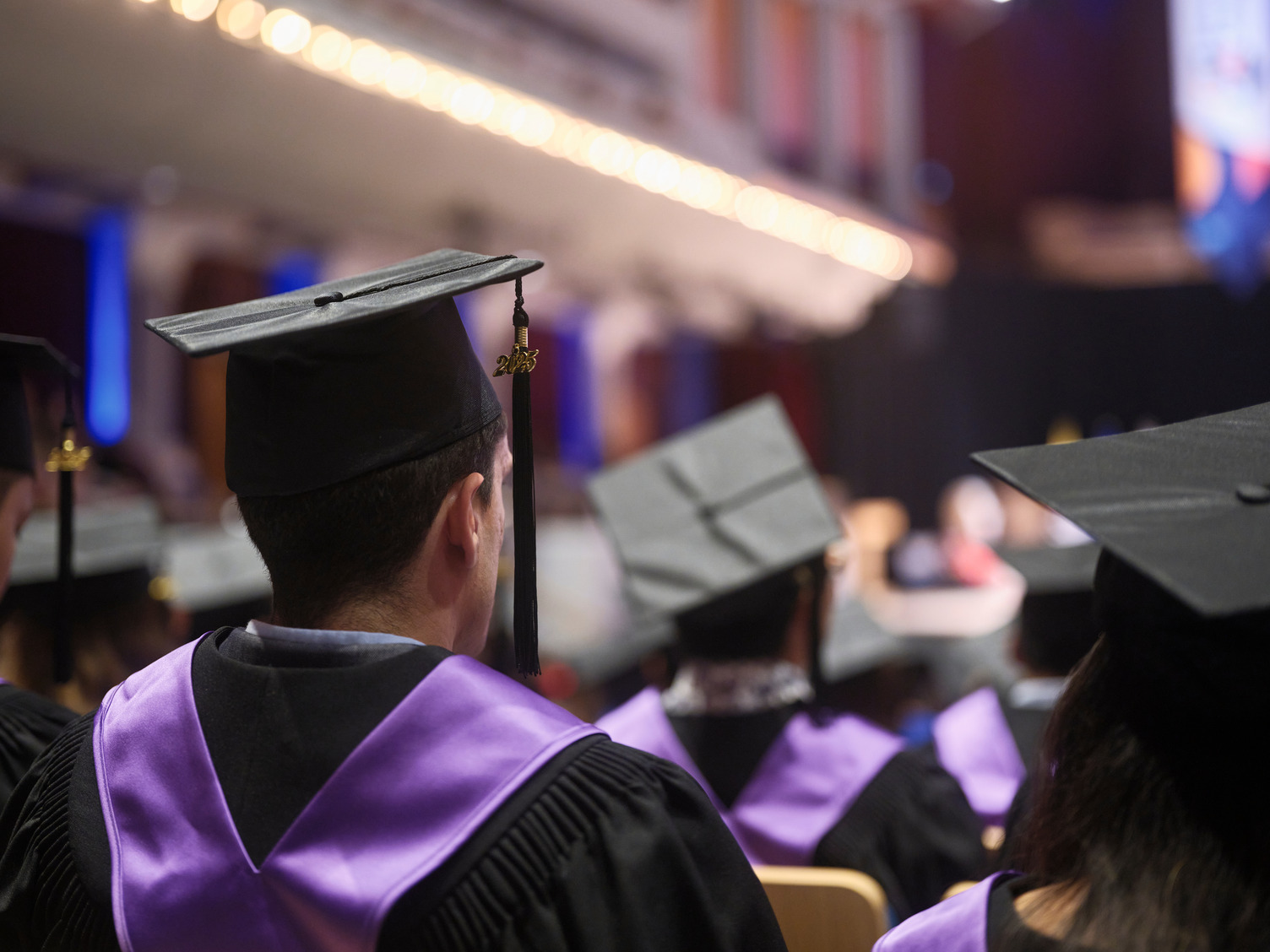 A BVC graduate at Werklund Centre wearing a graduation gown with a purple stole.