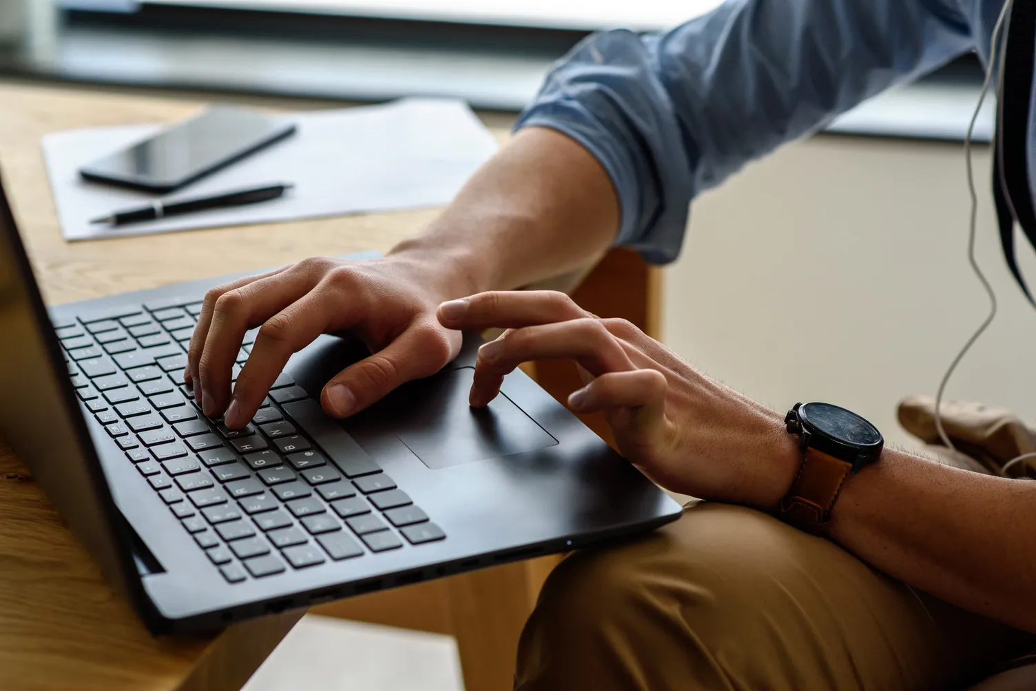 A shot of the hands of a student on her laptop.