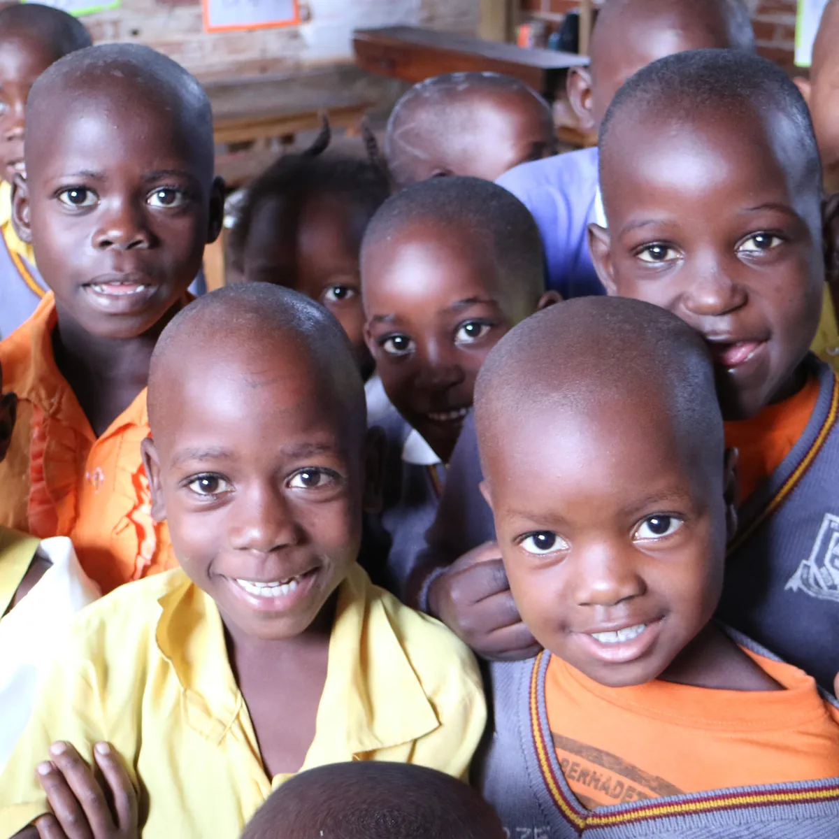 A crowd of smiling schoolchildren gathered close together