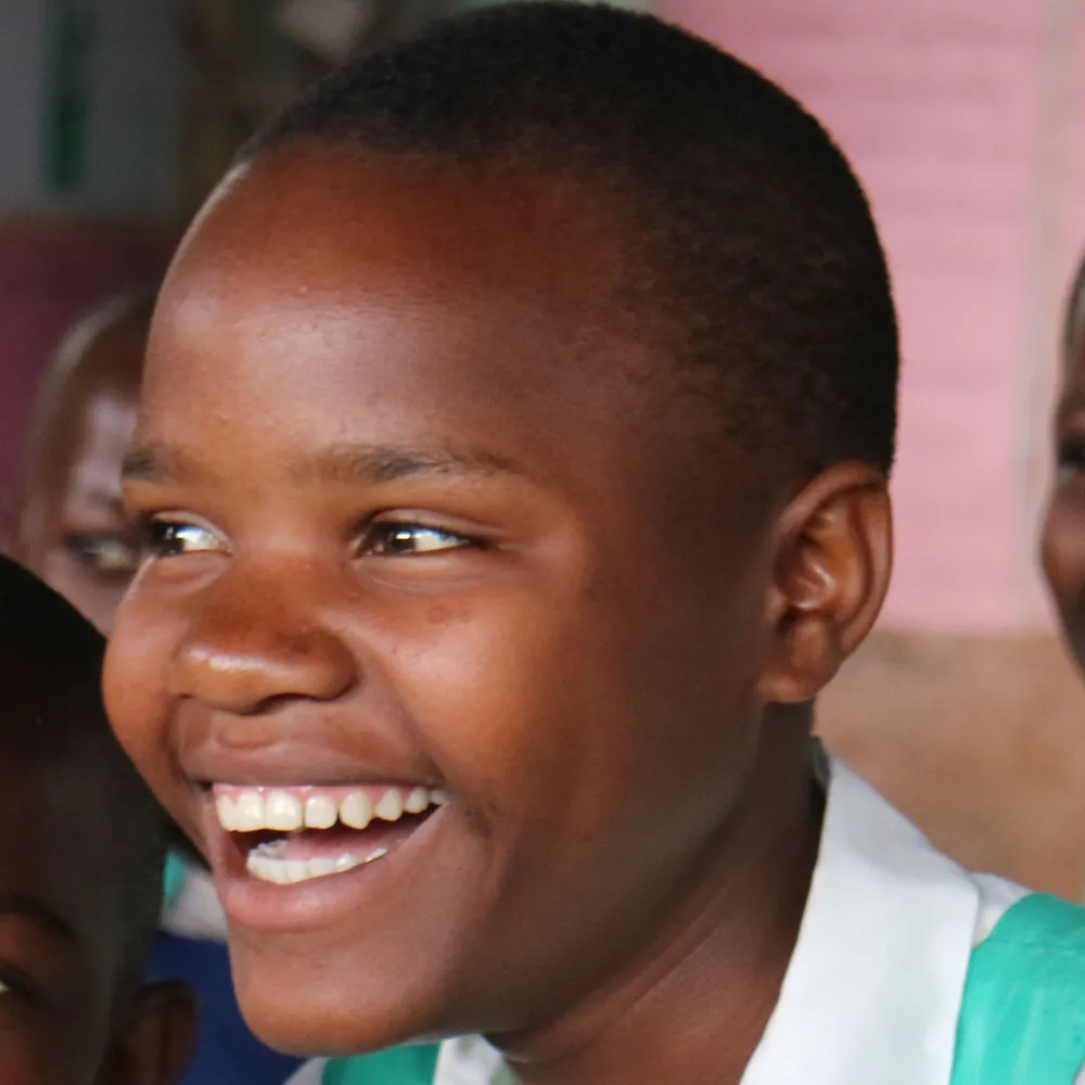 A child in a school uniform laughing