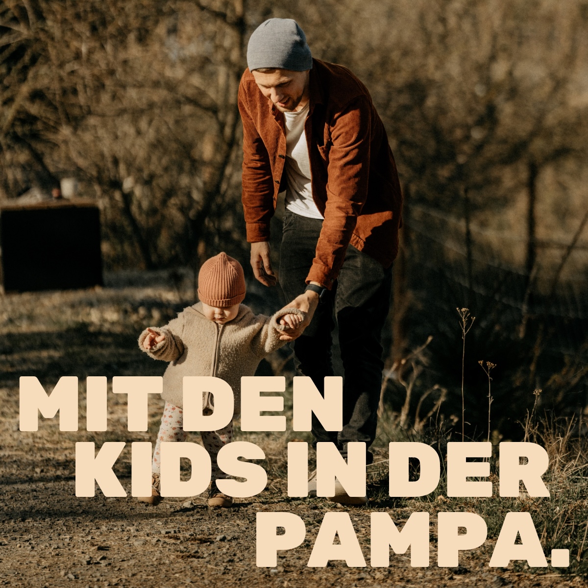 Vater geht mit Kleinkind an der Hand über einen Feldweg in der Natur