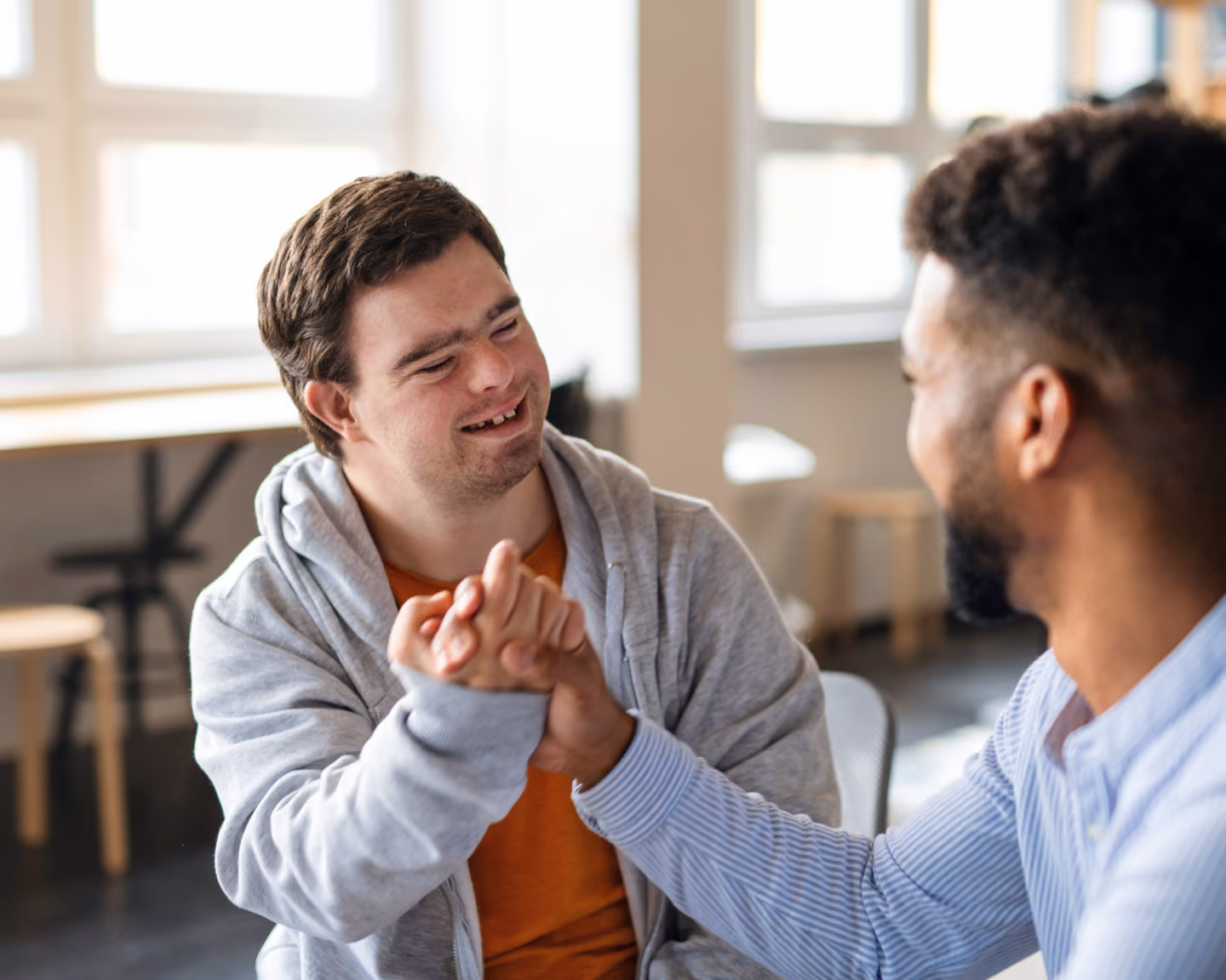 Deux jeunes hommes se tapent dans la main en souriant