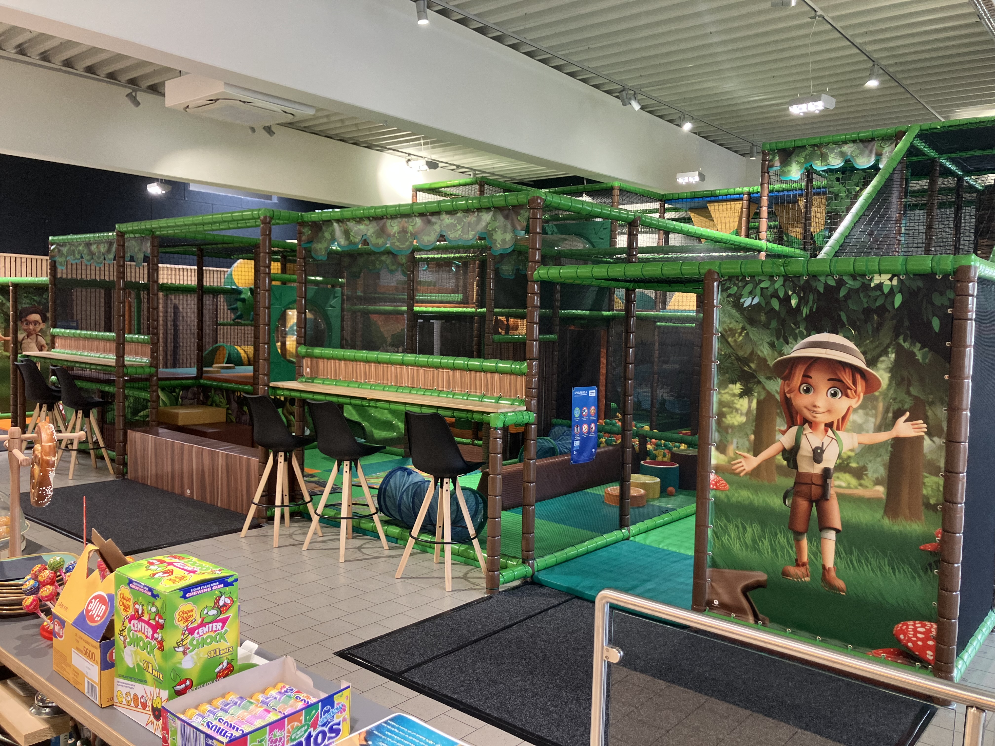 Ein Mädchen kommt Freude strahlend aus der Rutsche des Indoor-Spielplatzes des Kraftwerk Althofens.