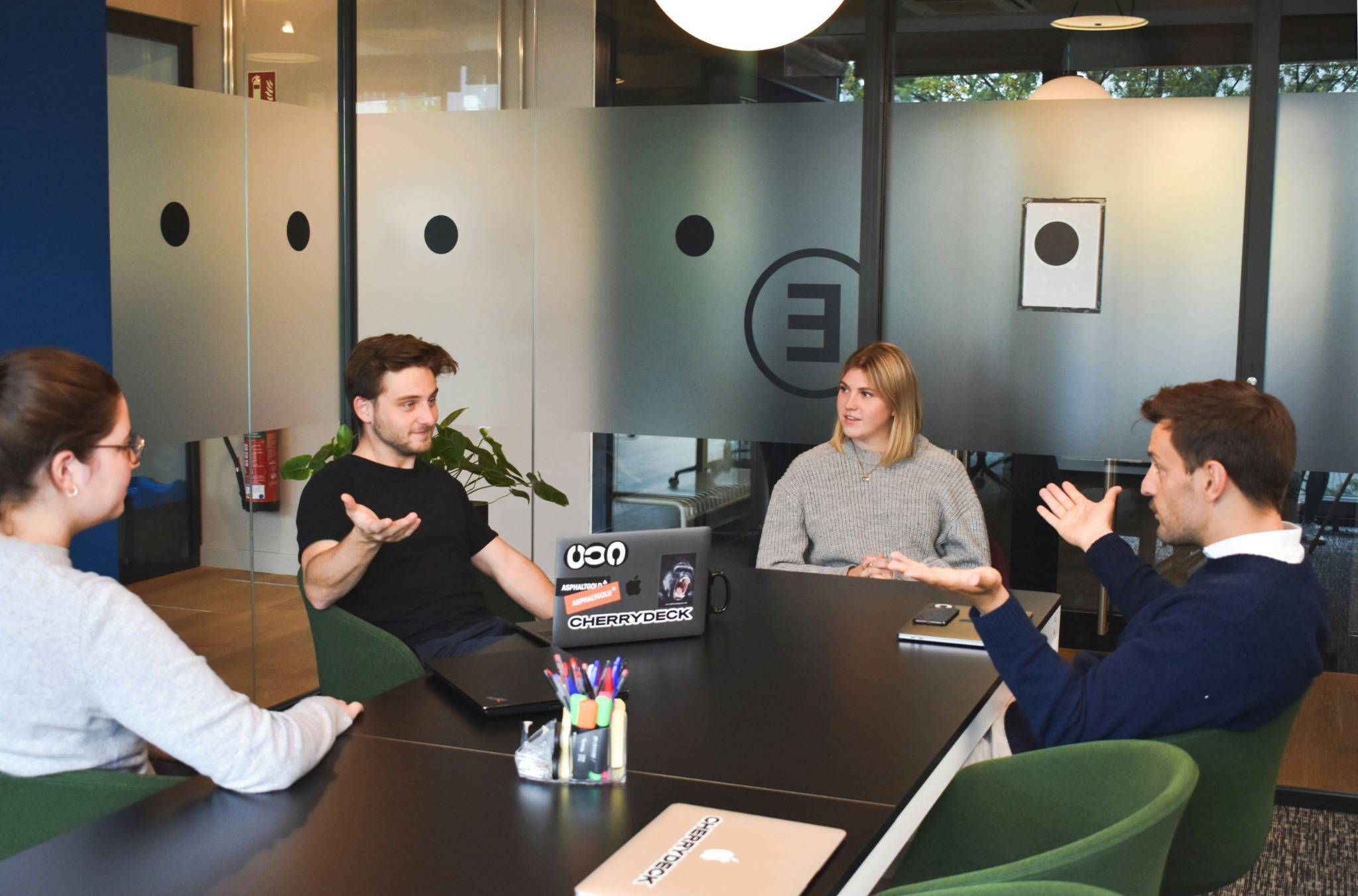 Réunion d’équipe informelle dans une salle moderne et collaborative.
