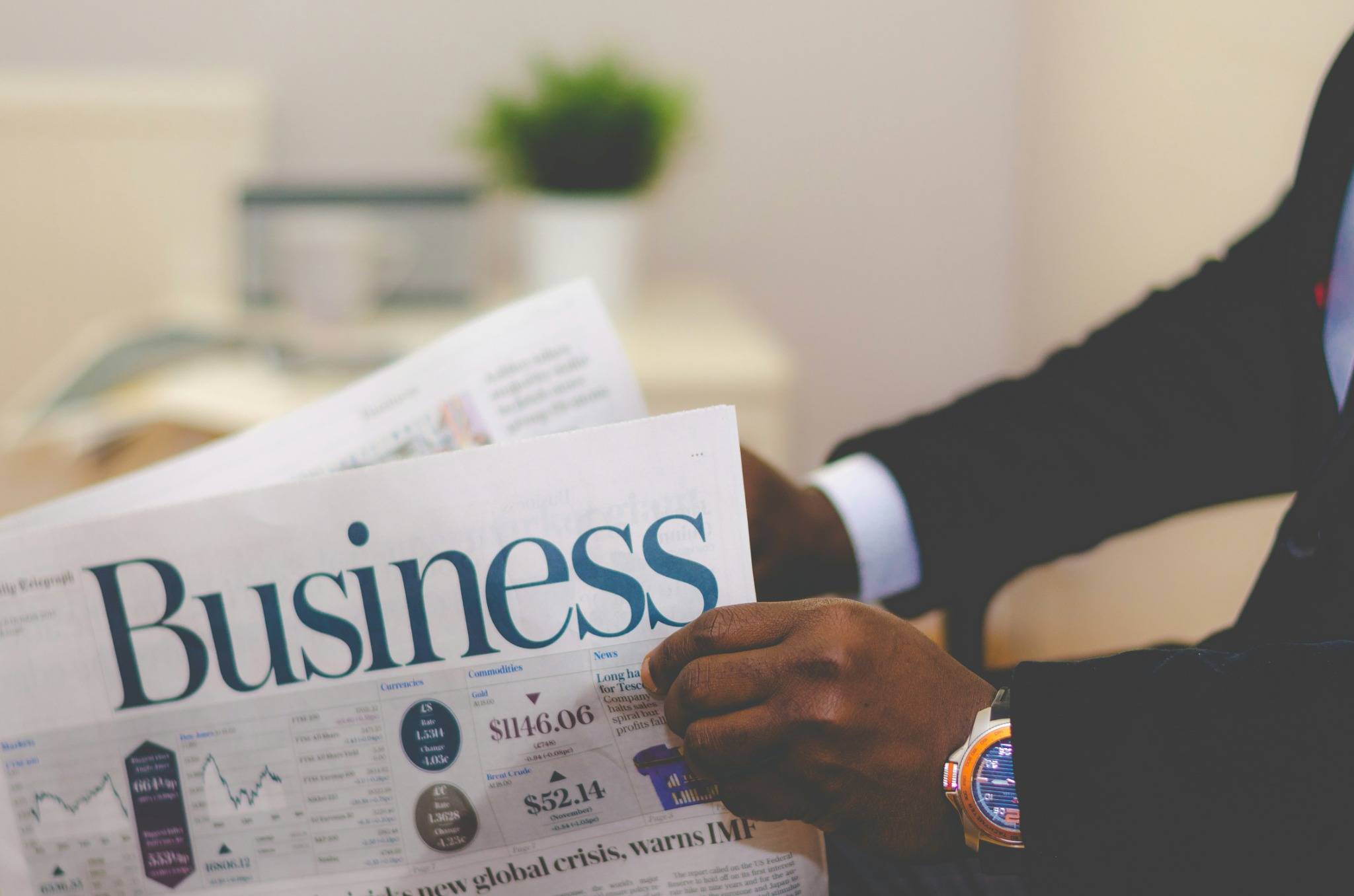 Un professionnel lit la presse économique pour rester informé des tendances du marché.