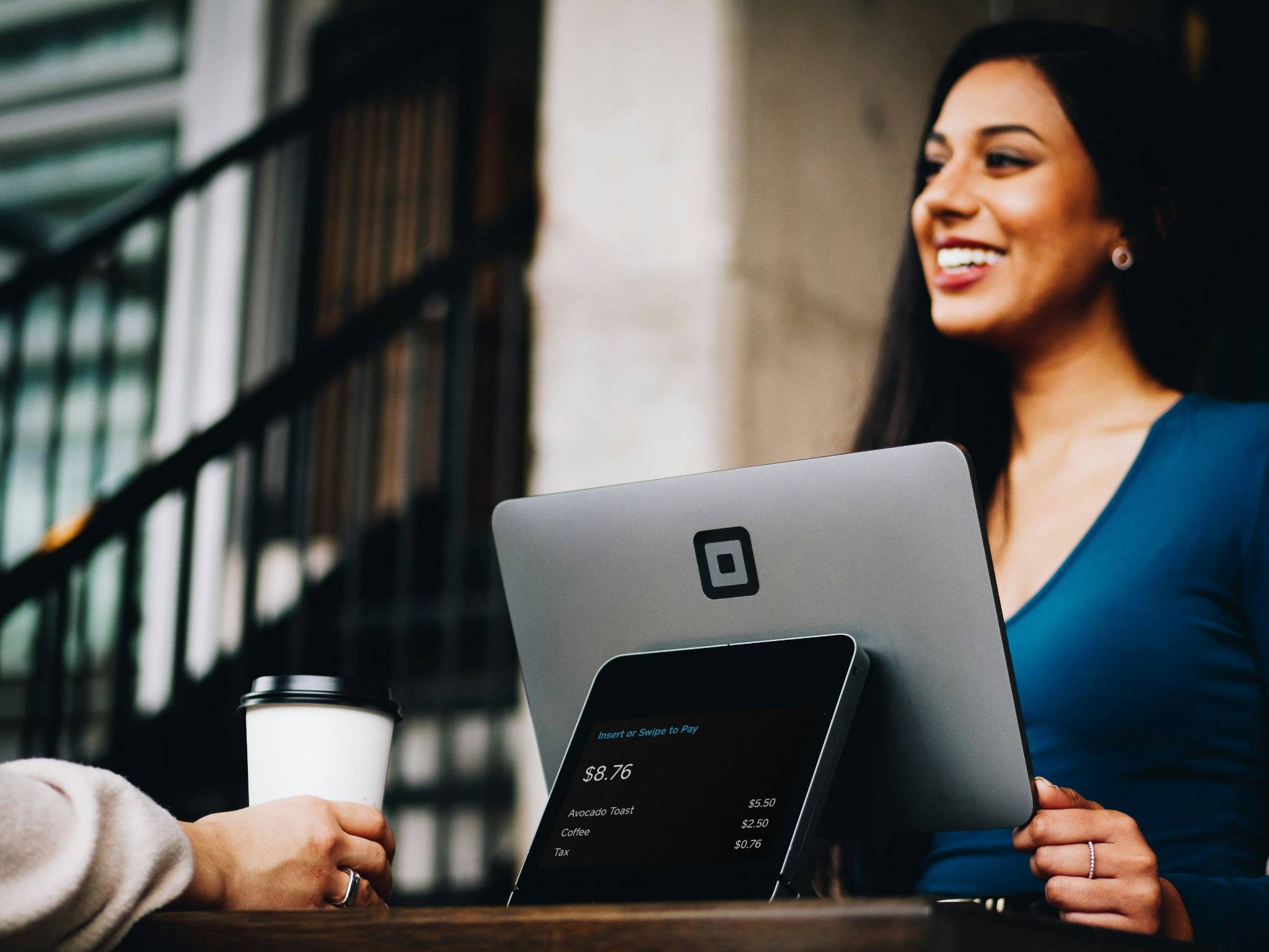 Une commerciale souriante échange avec un client dans un cadre décontracté.