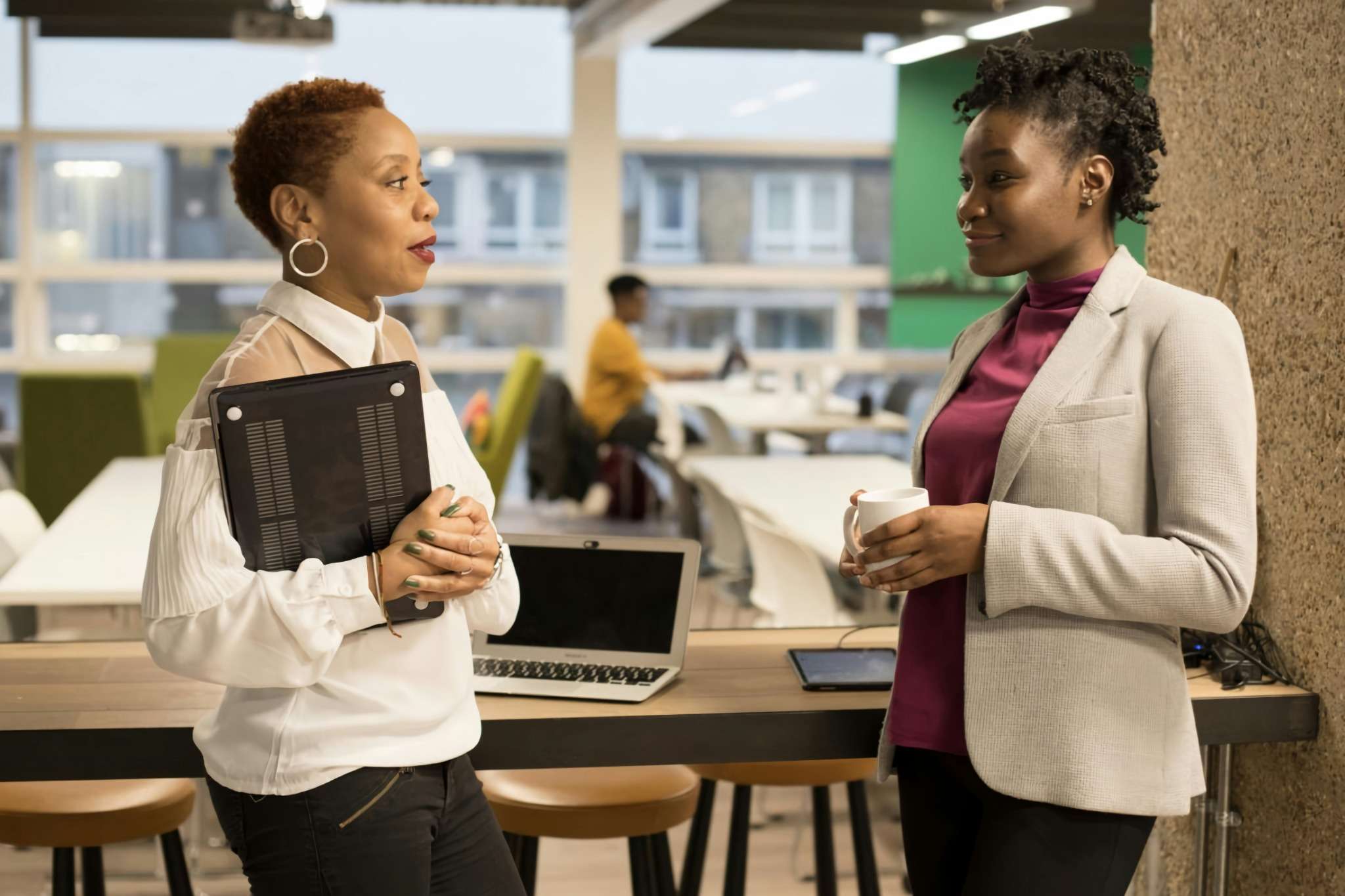 Deux professionnelles échangent dans un espace de coworking : illustration idéale pour la dimension relationnelle (levier Sympathie).