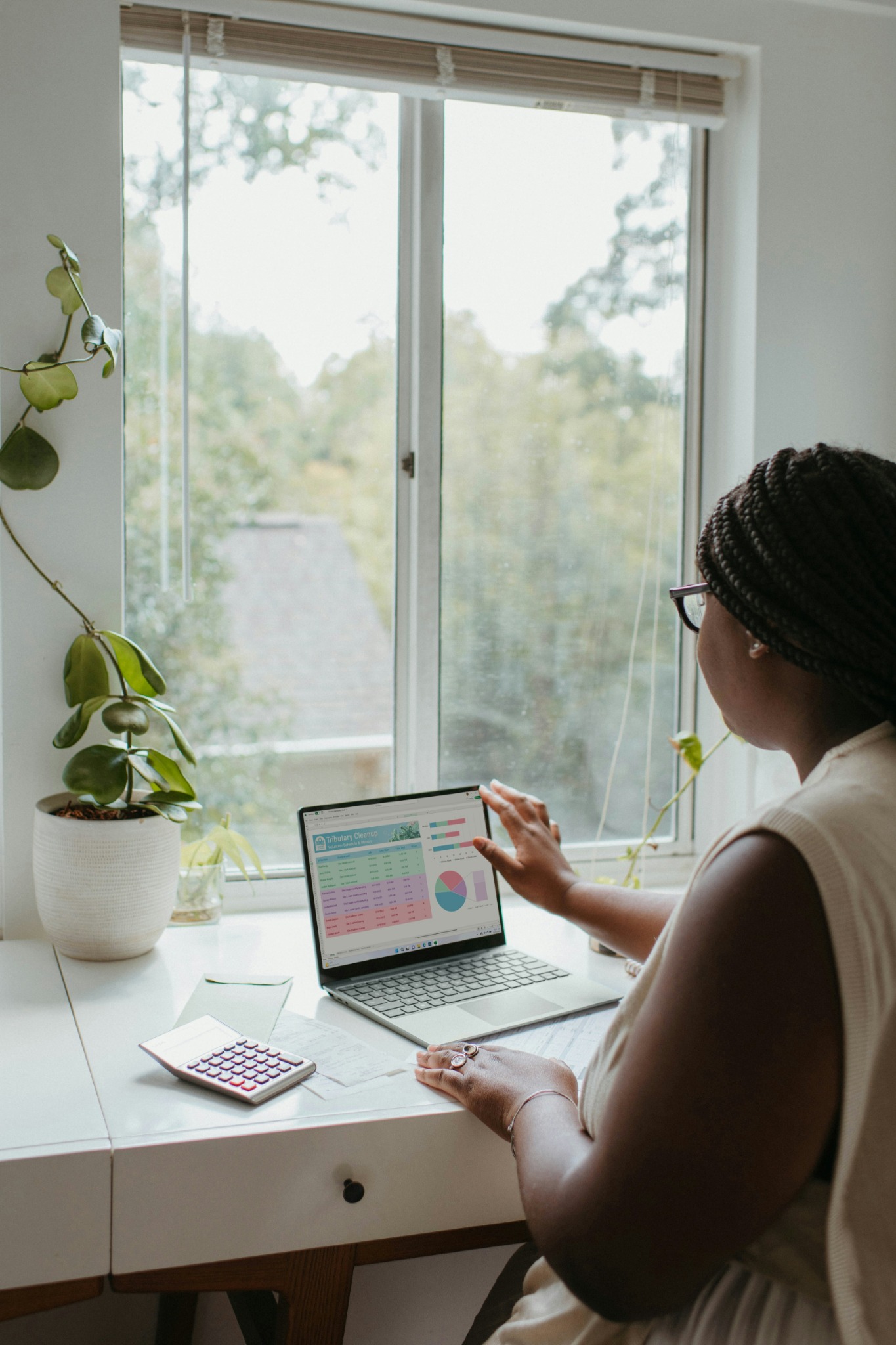 Travail à domicile – une professionnelle analyse des données sur son ordinateur portable, avec graphiques et tableaux.