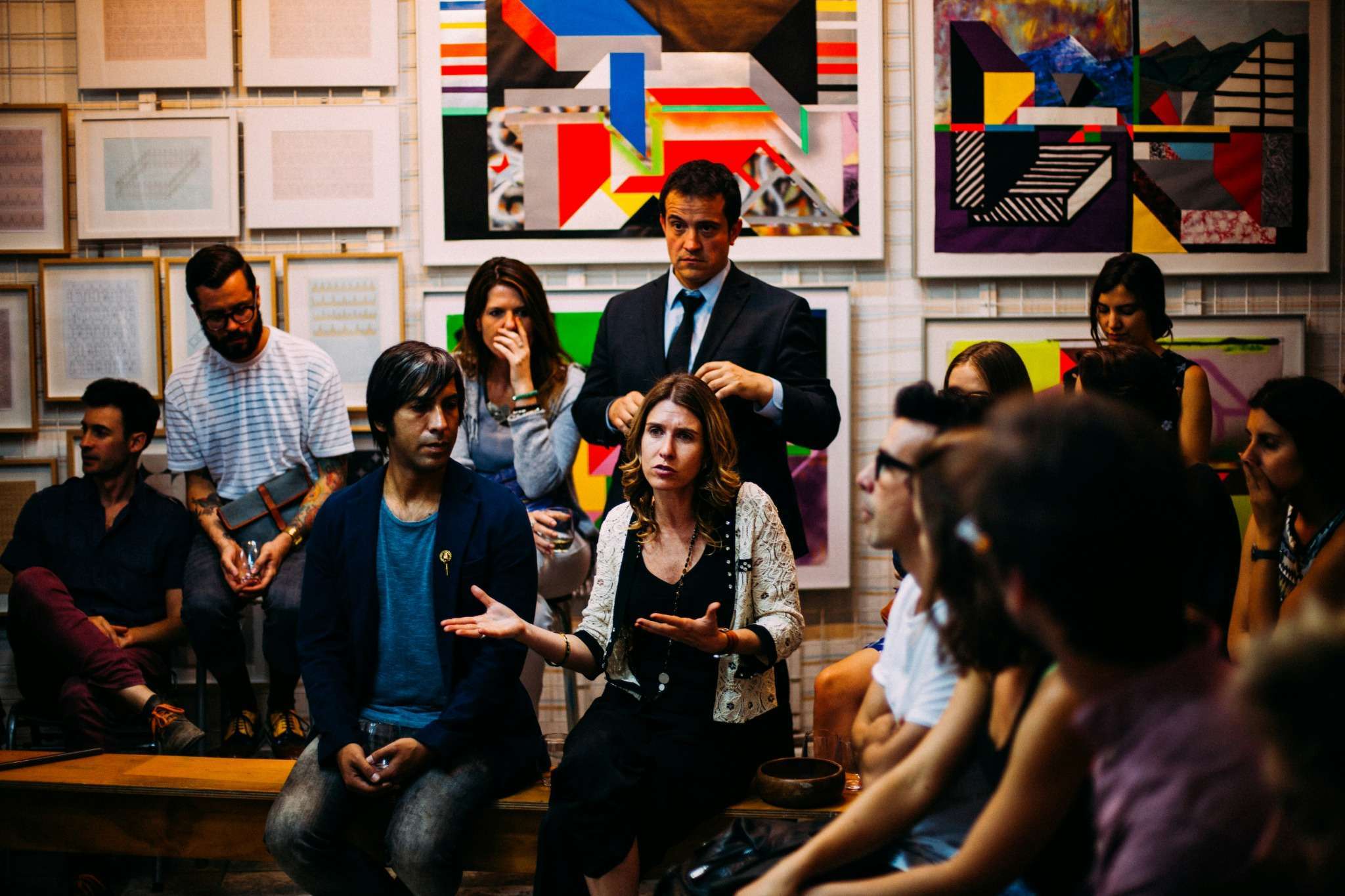 Un groupe de personnes échange lors d’une discussion animée dans un cadre artistique.