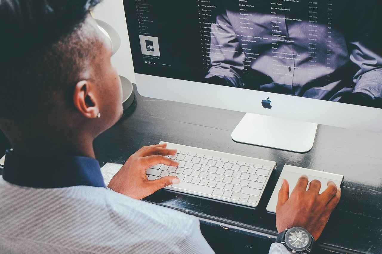 Un professionnel utilise un ordinateur de bureau pour consulter et gérer des contenus multimédias.