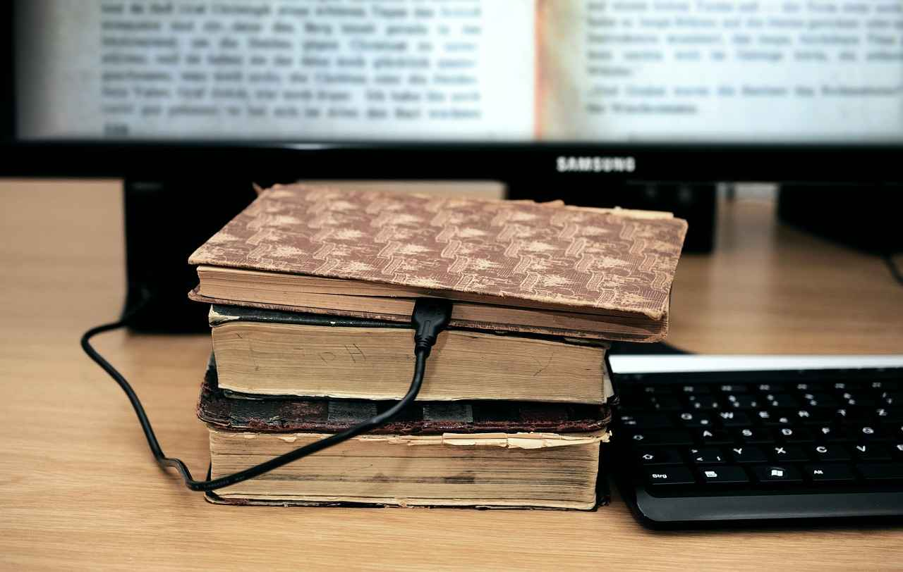 Des livres reliés connectés à un ordinateur, représentant la connaissance et la structuration des données nécessaires à la qualification des leads.