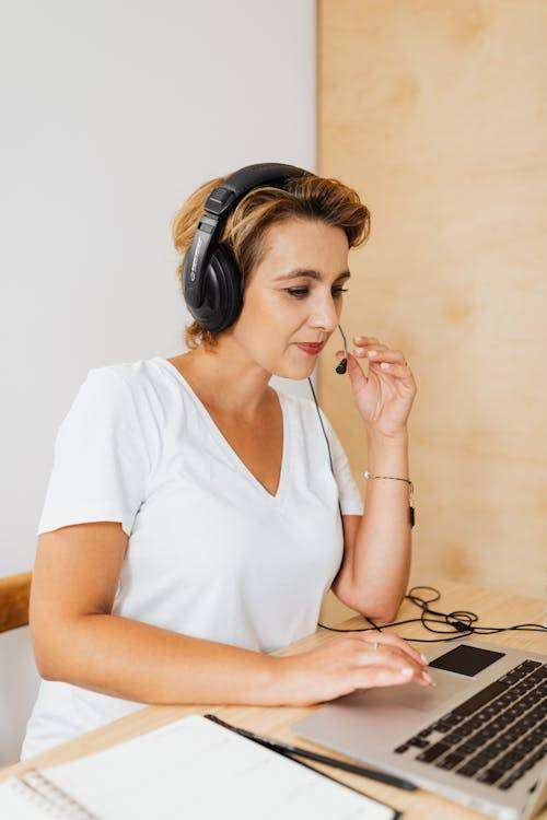 Commercial travaillant à distance avec un casque et un ordinateur portable, concentré sur son activité.