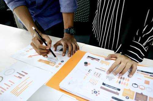 Collaboration entre deux professionnels autour de graphiques et de données pour optimiser la prospection.