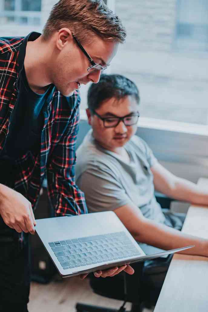 Deux collaborateurs optimisent une campagne email sur un poste de travail.