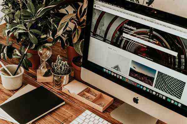 Un bureau avec un écran d'ordinateur affichant un site web de photographie, soulignant l'importance des visuels dans les campagnes Facebook Ads.