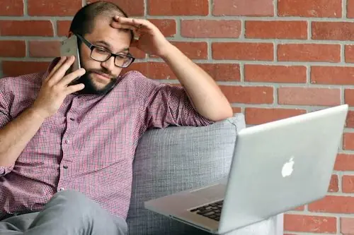 Commercial en phase de prospection téléphonique analysant son pipeline sur ordinateur.