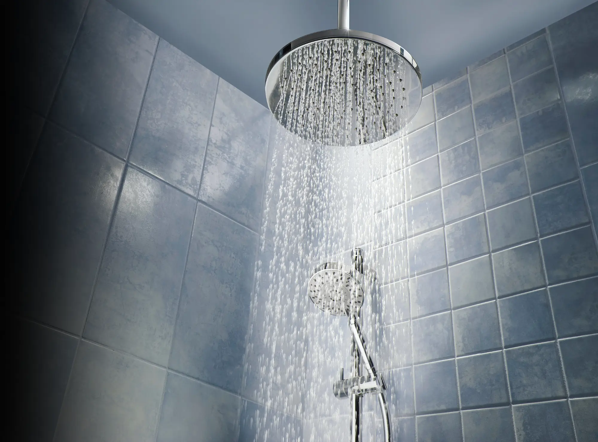 A shower with a silver shower head and a silver shower hose.