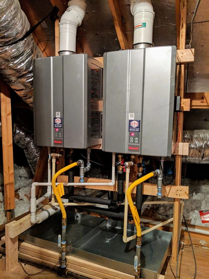 Two tankless water heaters installed in an attic