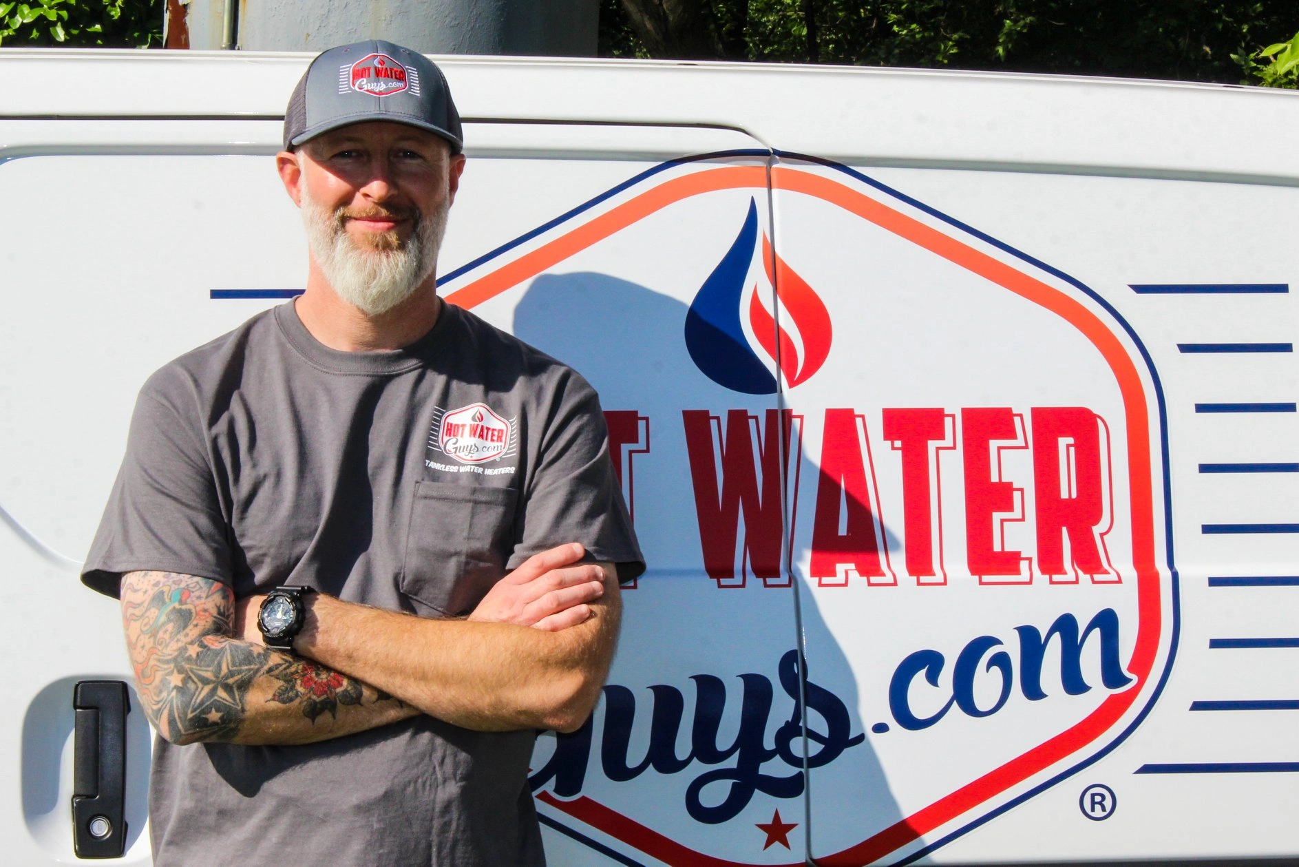 Hot Water Guys team member standing in front of a Hot Water Guys service van