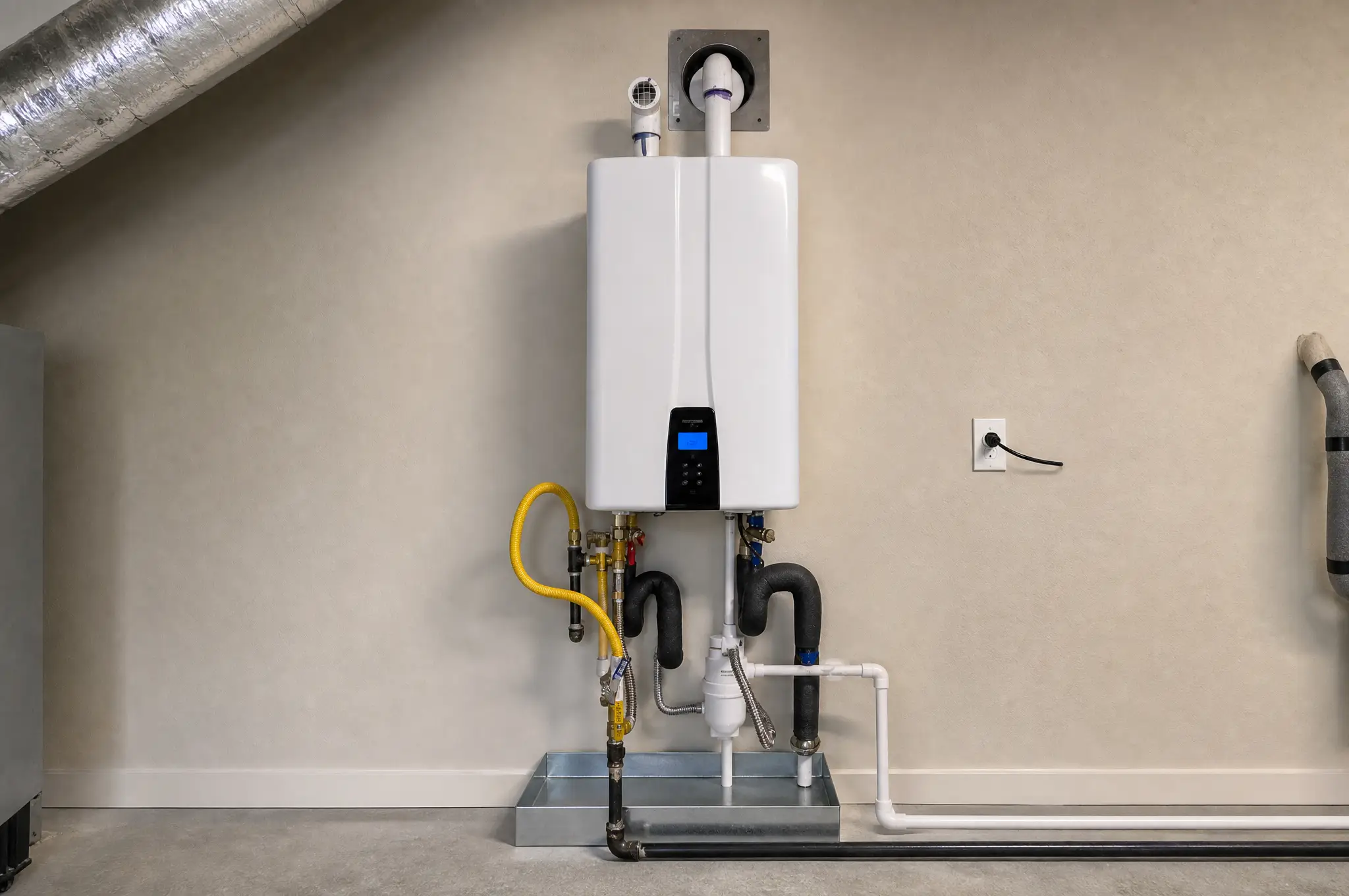 Wall-mounted condensing tankless water heater installation with PVC venting and isolation valves in Houston