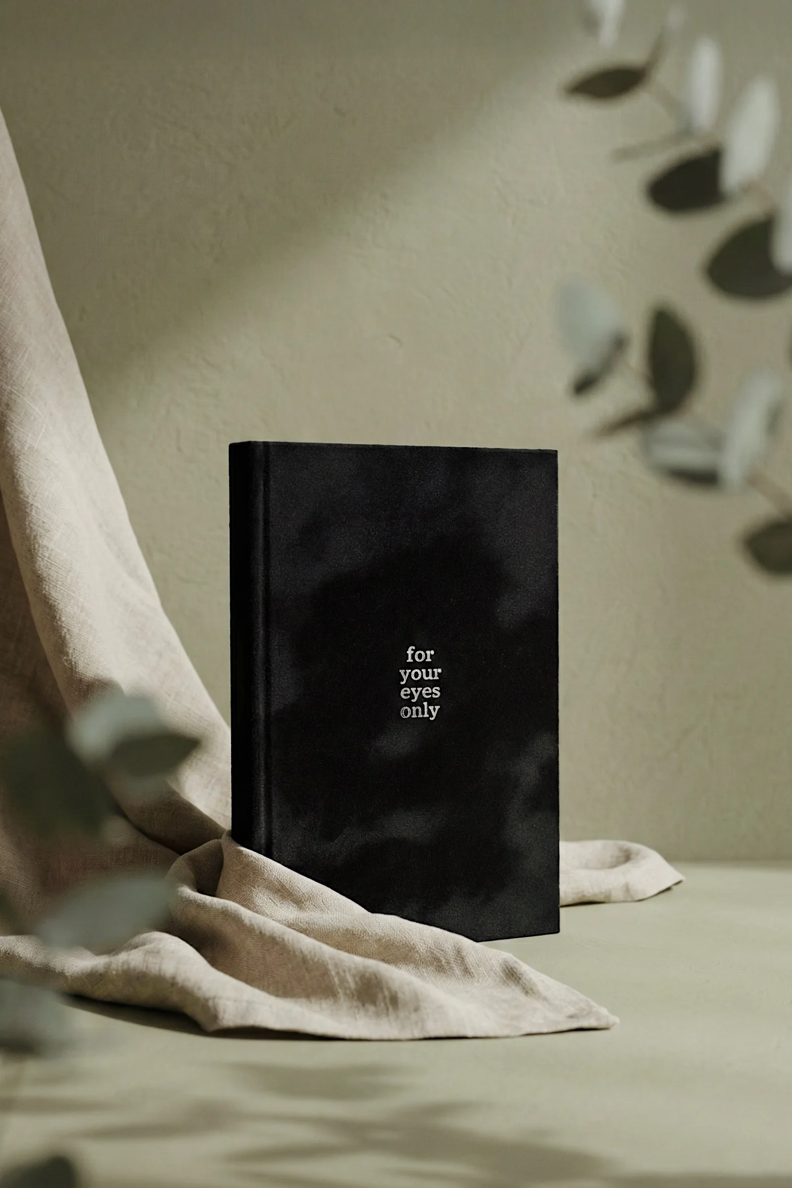 Black photo album displayed in a neutral interior