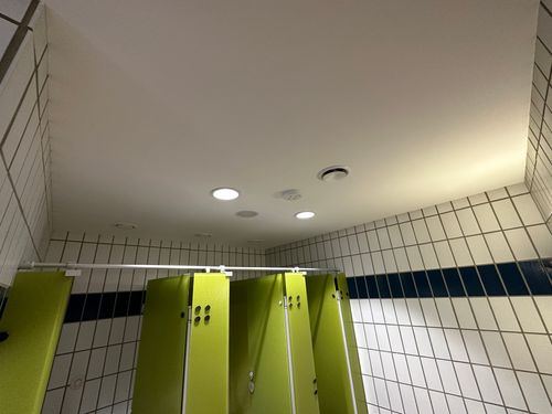 Renovierte Toilettenanlage im Wellenbad Ellwangen mit neuen Deckenleuchten und moderner Aquapanel-Deckenverkleidung
