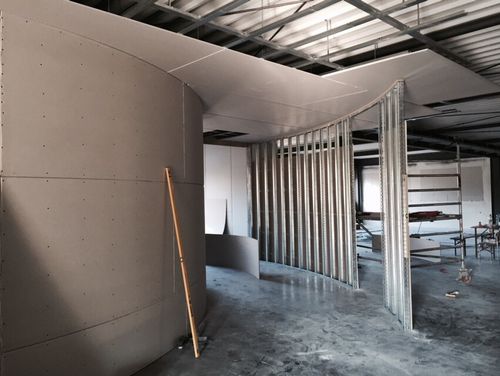 Bauarbeiten an abgerundeten Trockenbauwänden in einem Bürogebäude in Aalen, Stahlkonstruktion und Vorbereitung für Innenausbau.