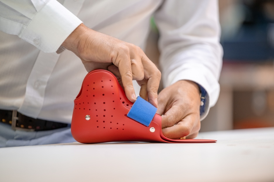 Person applying velcro to a 33-printed ankle-foot orthosis