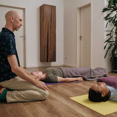 Miguel praktiziert Hypnose + Breathwork mit zwei Teilnehmerinnen