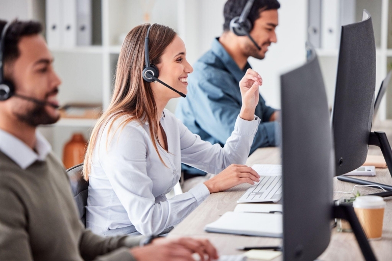 Customer service team working at desks with headsets
