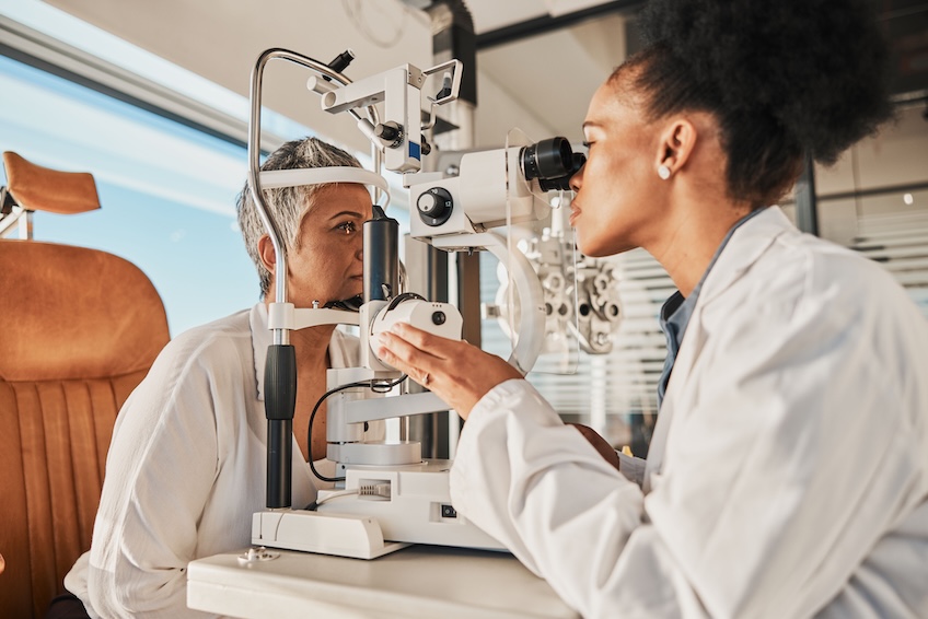 Optometrist evaluating a patient using a slit lamp