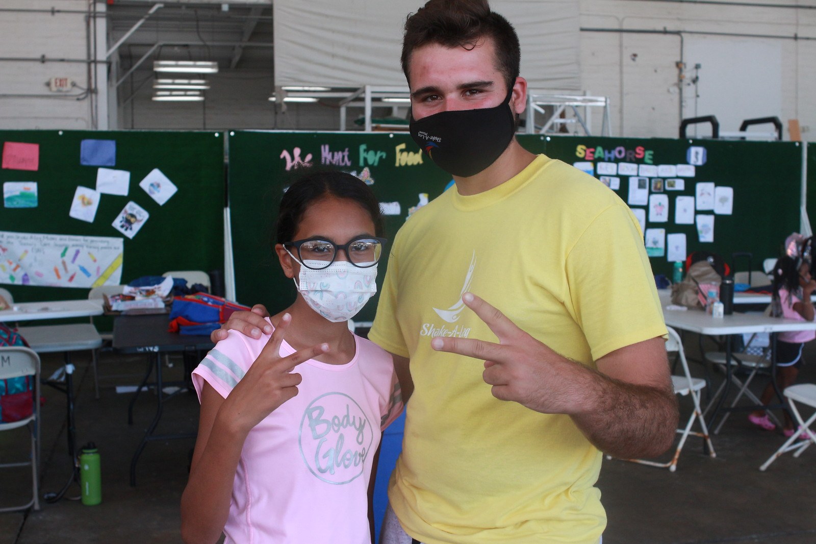 A camper and a counselor in masks at summer camp during the pandemic