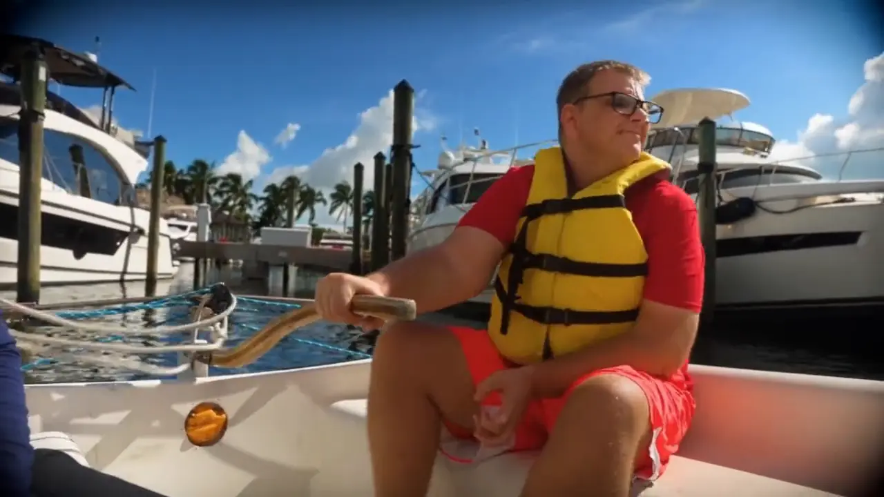 A sailor in a yellow life jacket at the tiller during a Shake-A-Leg Miami class
