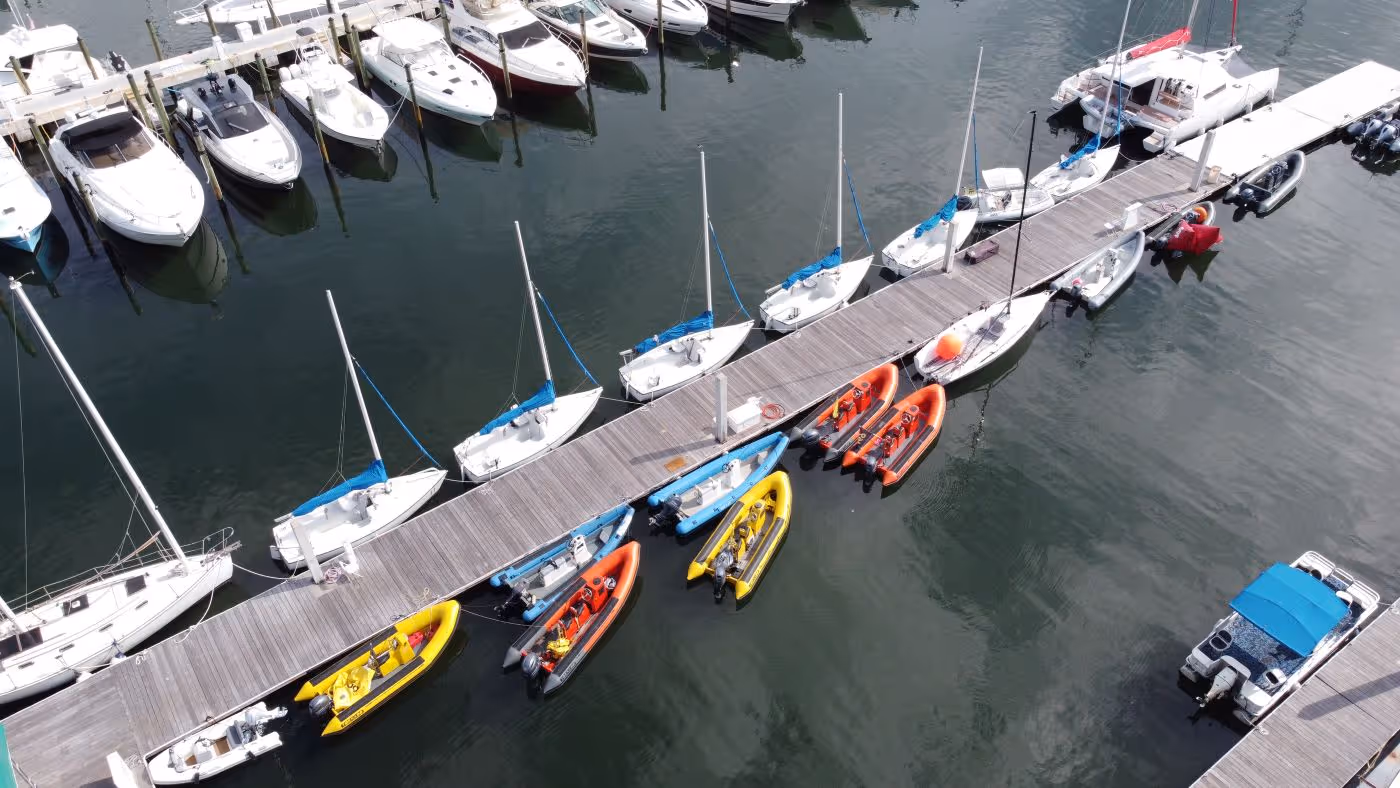 Aerial view of the Shake-A-Leg Miami dock, with small sailboats and inflatable boats tied up along it