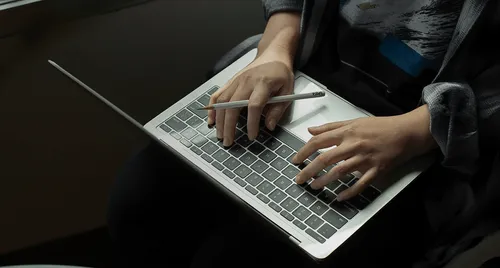 A person typing at their notebook