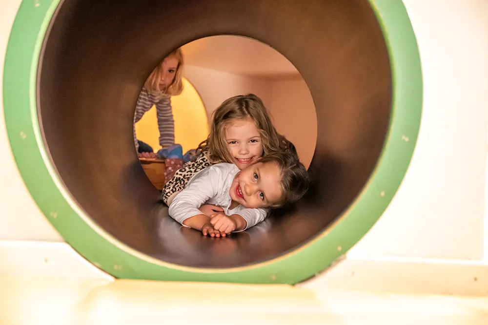 Zwei Kinder liegen in einem Tunnel