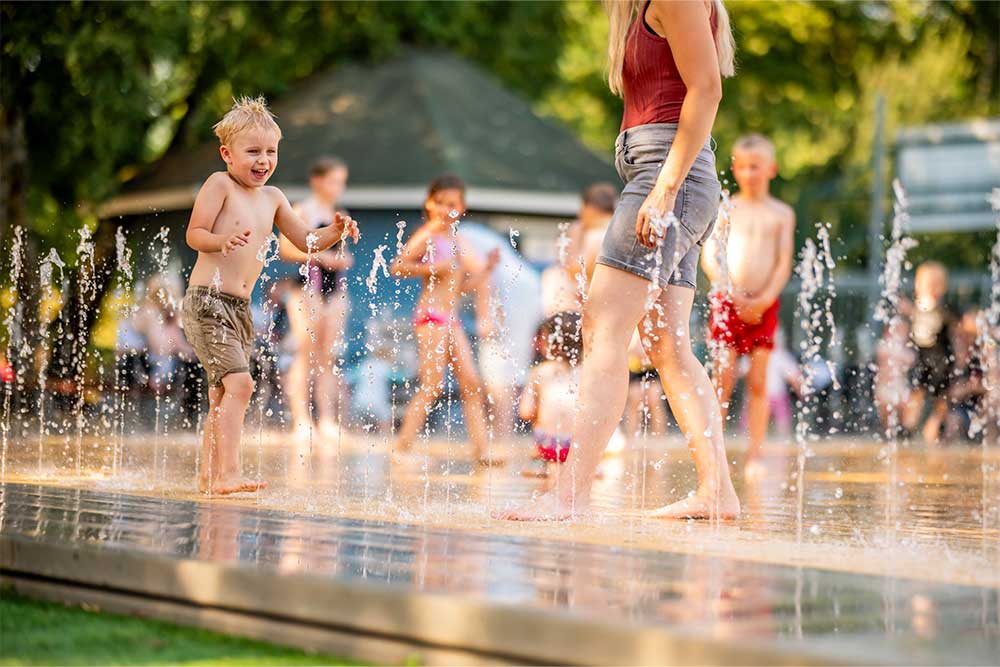 Kinder spielen in einer Wasserfontäne