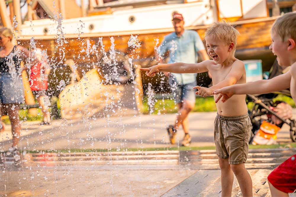 Kinder spielen in einer Wasserfontäne