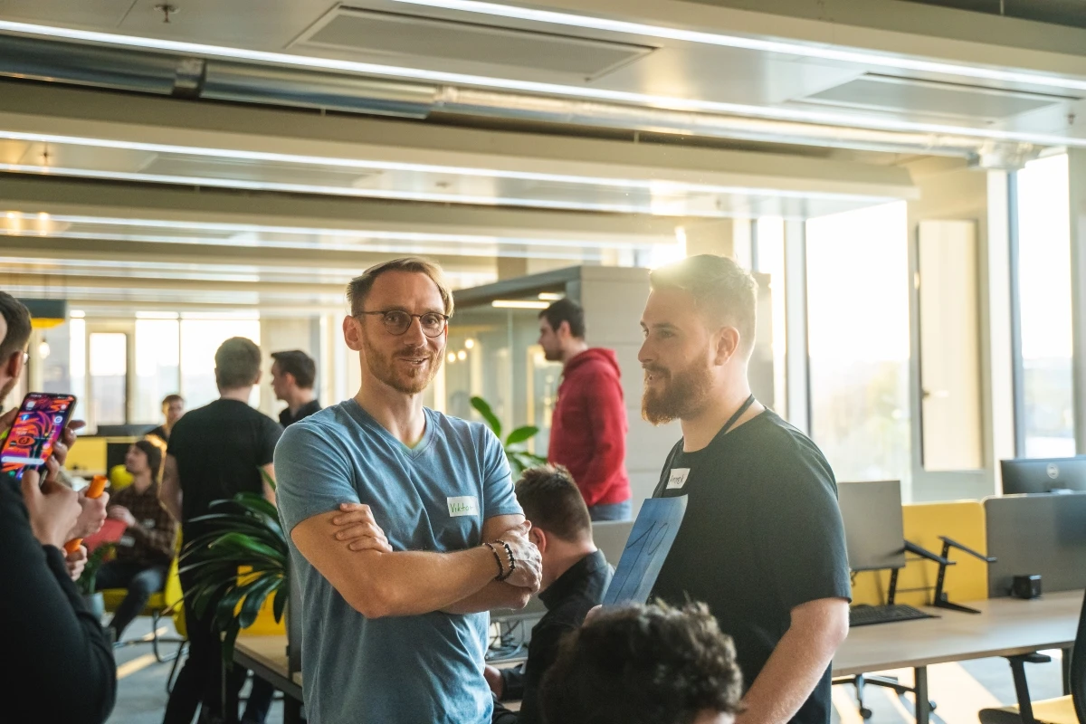 Developers talking in sunny Cleevio office before hackaton start