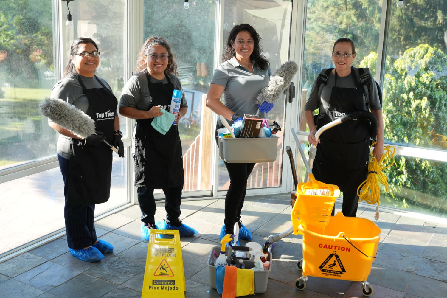 Top Tier Environmental Services crew posing with cleaning equipment