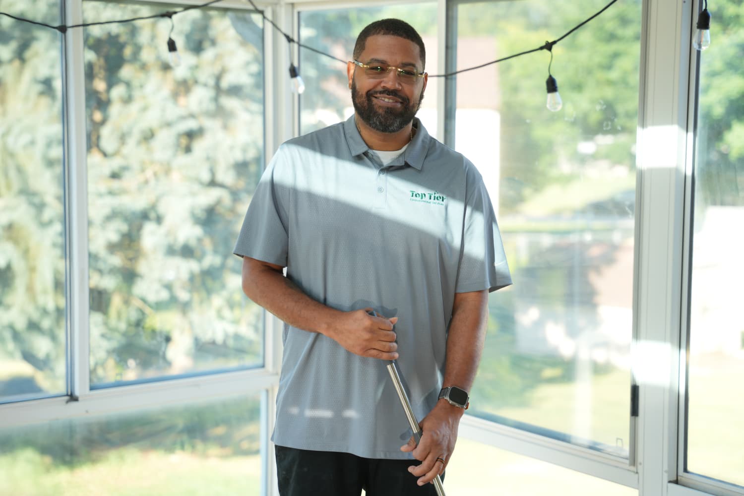 Top Tier Environmental Services owner posing with broom