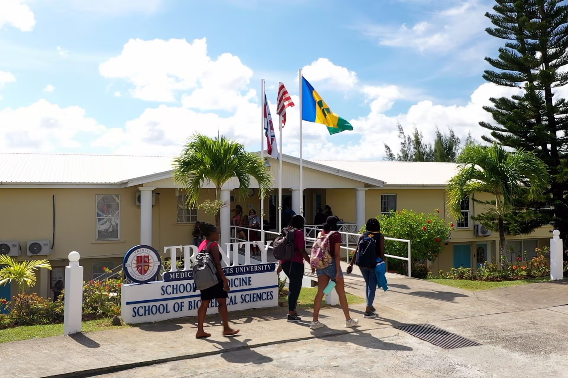 Medical students walking past the Trinity School of Medicine sign and into one of the school buildings in St. Vincent.
