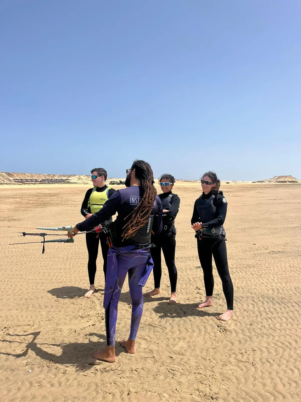 Kitesurf instructor teaching a small group during a lesson on the beach at Dakhla Lagoon with Mirage Dakhla.