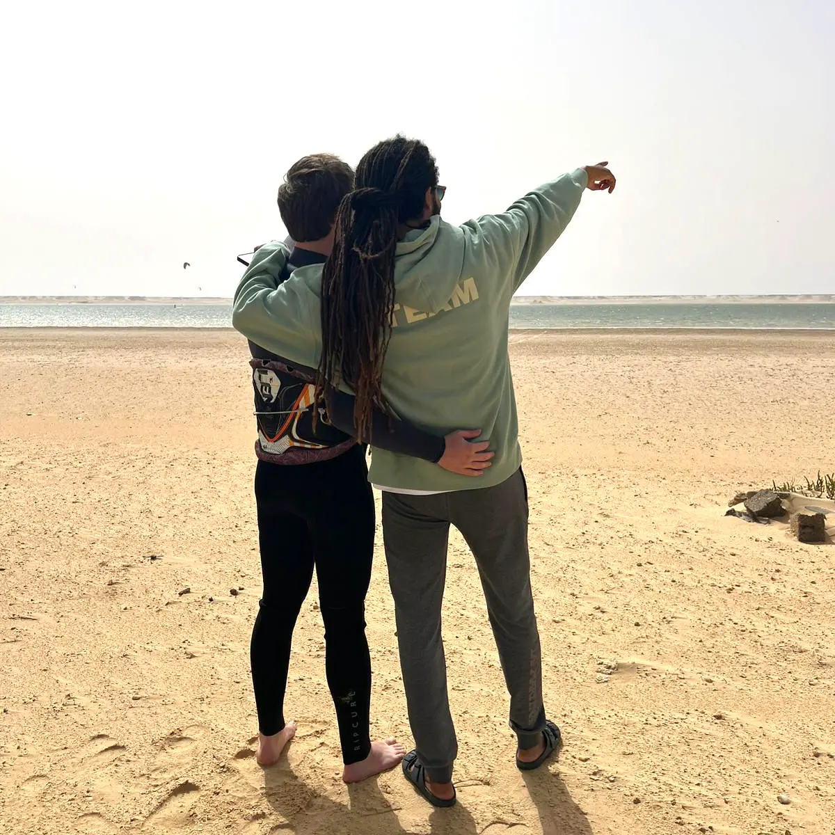 Kitesurf instructor guiding a student on the beach at Dakhla Lagoon before entering the water.