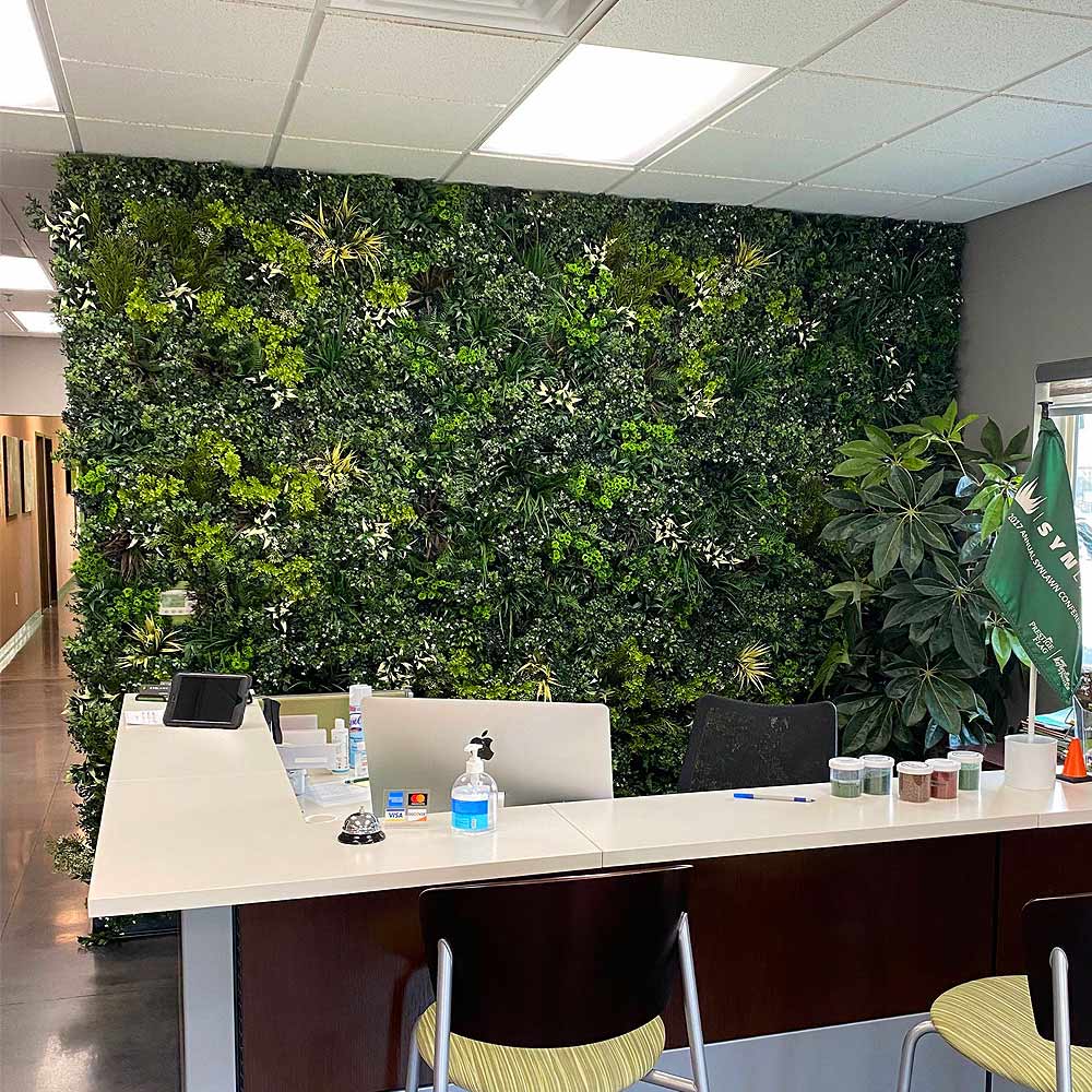 An interior office wall accented with artificial plant panels. 
