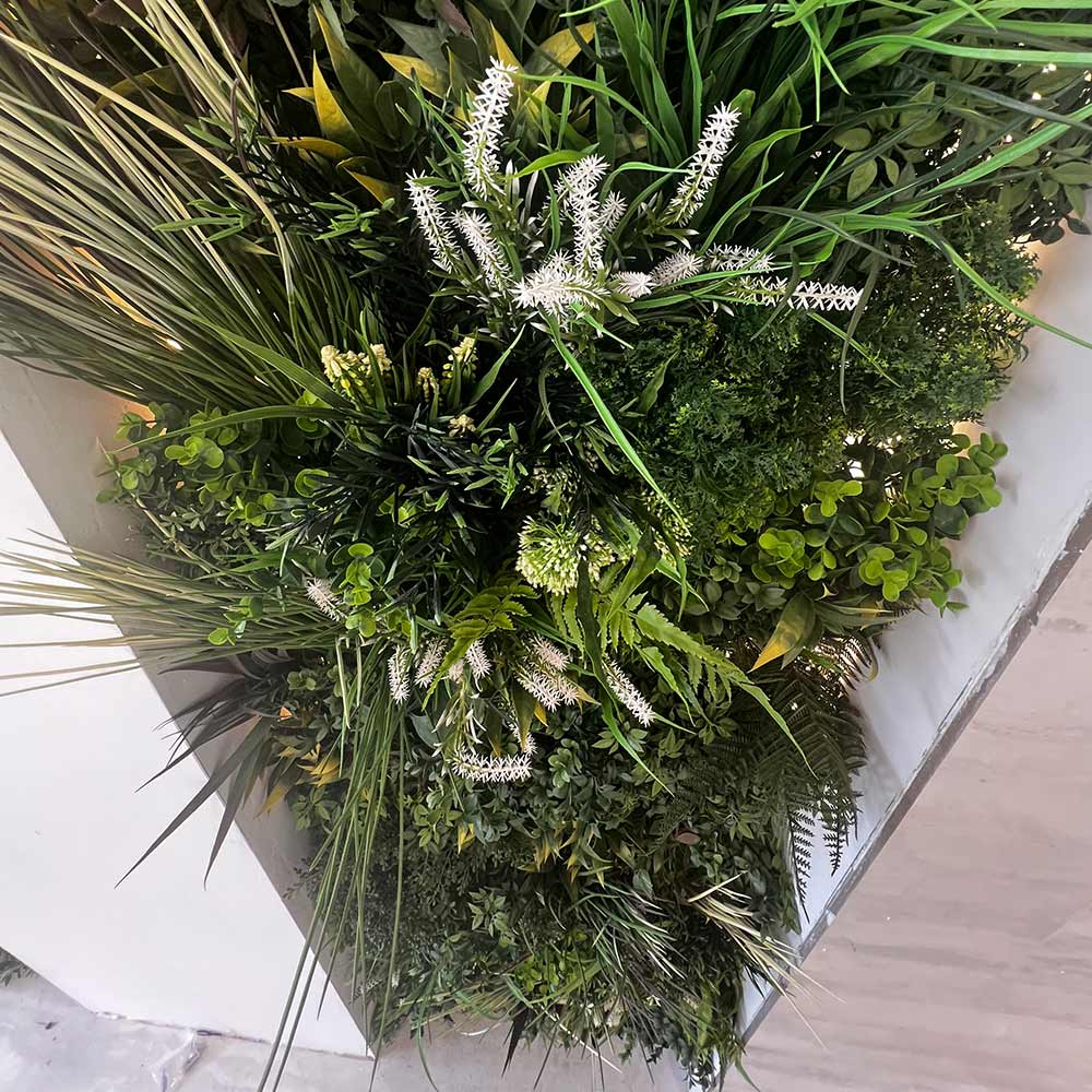 A closeup view looking to an artificial plant wall panel