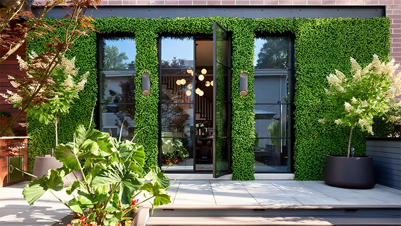 An exterior building with beautiful plant walls around the windows and doors