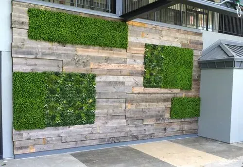 Exterior walls covered with reclaimed wood and artificial plant walls
