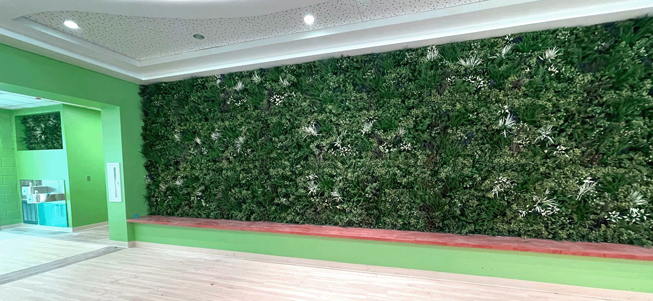 Large wall accented with green artificial plants