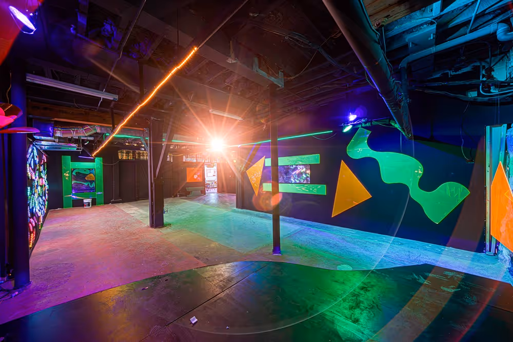 Vibrantly lit event space inside The Supermarket Atlanta, featuring bold geometric murals, colorful LED installations, and an open layout designed for creative gatherings and immersive experiences.